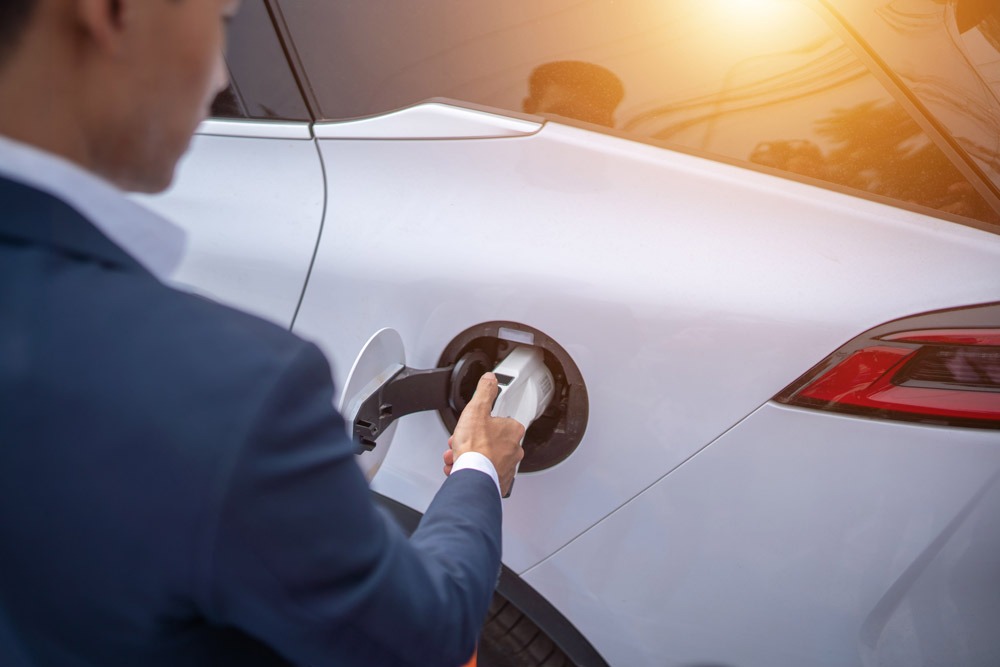 young businessman charges an electric vehicle at a 2023 01 05 02 21 00 utc