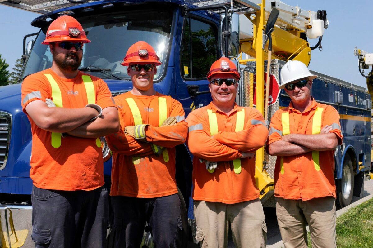 Enova staff stand in front of Enova truck