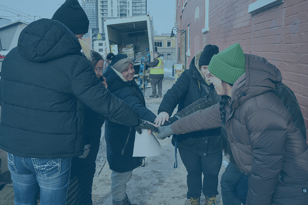 The Working Centre employees huddle together to cheer